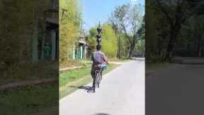 Bicyclist Balances Jugs On Head
